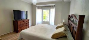 a bedroom with a bed and a flat screen tv at Departamento en Condominio Buganvillas in Santa Cruz de la Sierra
