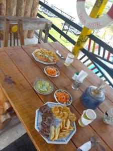 une table en bois avec des assiettes de nourriture et des frites dans l'établissement Faera Hostel, à Darién