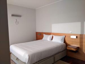 - une chambre avec un grand lit et des draps blancs dans l'établissement Duplex by the Beach, à Ovar