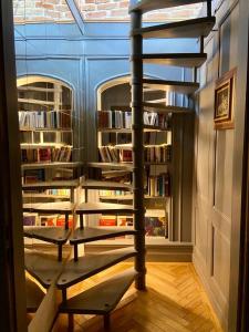 eine Wendeltreppe in einer Bibliothek mit Bücherregal in der Unterkunft Un petit nid atypique au cœur de Munster in Munster