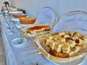 a table topped with trays of pastries and pies at Pousada Hippopotamus Jeri in Jericoacoara