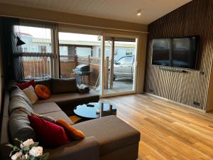 a living room with a couch and a flat screen tv at The Lava Bowl in Grindavík