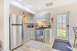 uma cozinha com armários brancos e um frigorífico de aço inoxidável em New Paltz Apt - 11 Mi to Poughkeepsie! em New Paltz