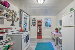 a kitchen with white appliances and a tree on the wall at Historic Marshall Log Cabin Less Than 1 Mi to Dtwn! in Marshall