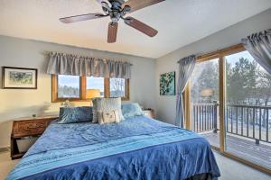 a bedroom with a blue bed and a balcony at Lake Nokomis Escape with Dock and Beach Access in Tomahawk