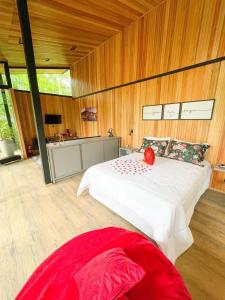 a bedroom with a large bed and wooden walls at Pousada Sitio Raizes in Siderópolis