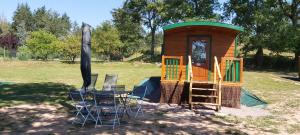 a small play house with a table and chairs at Les Roulottes des Ris in Vallon-en-Sully