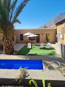 een huis met een tuin met een groen gazon bij Cabañas y Loft Parronal in Vicuña
