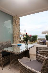 una sala da pranzo con tavolo in vetro e sedie di Steleni Seaside Apartments a Iraklitsa