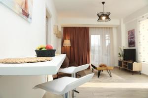 sala de estar con mesa blanca y sillas en Steleni Seaside Apartments, en Nea Iraklitsa
