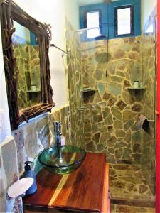 y baño con lavabo de cristal y ducha de piedra. en La Madremonte en Filandia