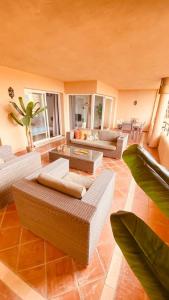 una gran sala de estar con sofás y mesas. en Elviria Apartment, en Marbella