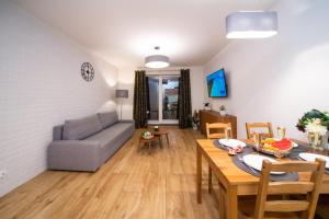ein Wohnzimmer mit einem Sofa und einem Tisch in der Unterkunft Maya's Flats & Resorts 43 -Swietej Babary in Danzig