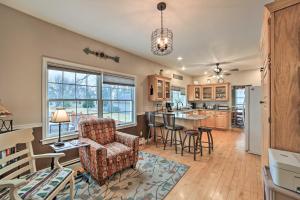 a kitchen and living room with a couch and a chair at Spacious Michigan Home with Private Hot Tub in Gladstone