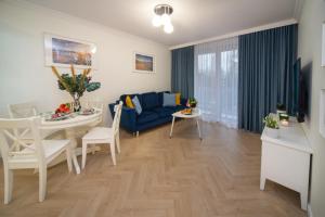uma sala de estar com um sofá azul e uma mesa em Maya's Flats & Resorts 53 - Aura 40 em Gdansk