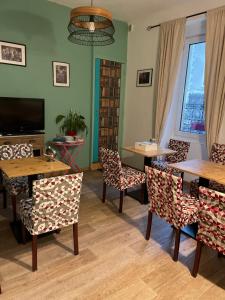 een eetkamer met tafels en stoelen en een tv bij hôtel la tour des fées in Quissac