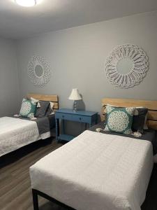 1 dormitorio con 2 camas y mesa con lámpara en The Bernice - 2 Bedroom Apt in Quilt Town, USA, en Hamilton
