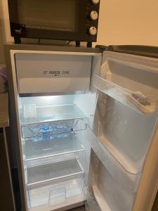 un frigorifero vuoto con la porta aperta in una cucina di The Nest Of Via Toledo a Napoli