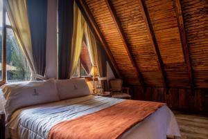 a bedroom with a bed in a room with windows at Hacienda Hostería Dos Chorreras in Cuenca