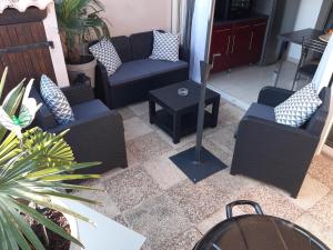 un patio avec plusieurs chaises, une table et des plantes dans l'établissement Pavillon 4/6 pers. 30 m² Gruissan Les Ayguades, à Gruissan