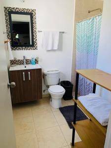 uma casa de banho com um WC, um lavatório e um espelho. em La Casa de Leo Recamara 1 Villa Cardiell QROO em Playa del Carmen
