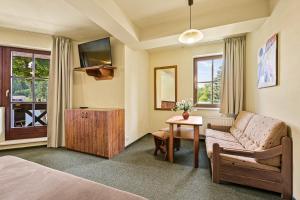 哈拉霍夫的住宿－大衛療養酒店，一间卧室配有一张床、一张沙发和一张桌子