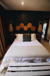 a bedroom with a large bed with a black wall at The Wild Edge First Light Cottage in Knysna +59 photos