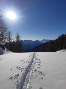a snow covered road with footprints in the snow at Hotel Meublè Meridiana in Valtournenche