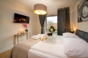 Un dormitorio con una gran cama blanca y una ventana en Maya's Flats & Resorts - River View, en Gdansk