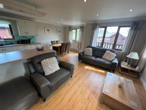 a living room with two leather couches and a kitchen at Jenny's Place Stunning 2 bedroom lodge in Sewerby