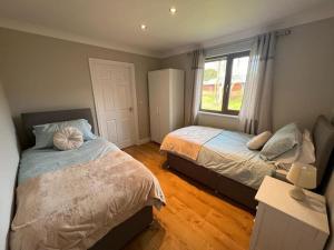 a bedroom with two beds and a window at Jenny's Place Stunning 2 bedroom lodge in Sewerby