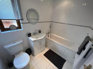 a bathroom with a toilet and a tub and a sink at Jenny's Place Stunning 2 bedroom lodge in Sewerby +21 photos