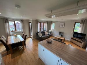 a living room with a couch and a table at Jenny's Place Stunning 2 bedroom lodge in Sewerby