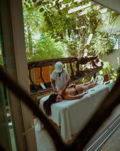カルタヘナ・デ・インディアスにあるLujosa Villa con Piscina Privada, Jacuzzi, Terraza, BBQ, AC muy Cerca de la Playaのベッドに座っている男と女