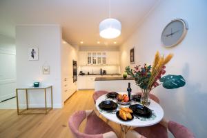 una cocina y comedor con una mesa con comida. en Maya's Flats & Resorts - River View en Gdansk