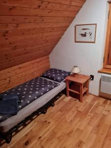 a bed in a room with a wooden ceiling at Chata u Rózy 2-Jasná, Demänovská dolina in Pavčina Lehota