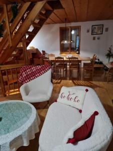 a living room with white chairs and a table and a dining room at Chata u Rózy 2-Jasná, Demänovská dolina in Pavčina Lehota
