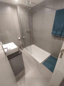 a white bathroom with a shower and a sink at Atlantic Blue I in Funchal