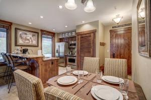 a kitchen and dining room with a wooden table and chairs at True Ski-in Ski-out Luxury Condo on Peak 7 condo in Breckenridge