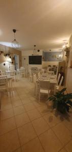 une salle à manger avec des tables et des chaises blanches dans l'établissement Castelvecchio B&B, à Sorano