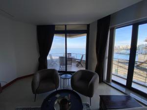 una sala de estar con sillas y vistas al océano. en Luxury Bay View 3 Bed 3 Bath Seafront Apartment in St Paul's Bay en St Paul's Bay