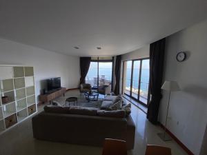a living room with a couch and a large window at Luxury Bay View 3 Bed 3 Bath Seafront Apartment in St Paul's Bay in St. Paul's Bay