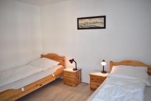 レンツァーハイデにあるLadina 65 (319 St)の白い壁とウッドフロアの客室で、ベッド2台が備わります。