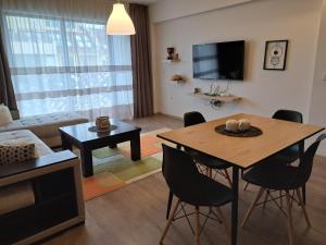 uma sala de estar com uma mesa e cadeiras e uma televisão em City Apartments 1 em Pazardzhik