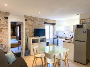 a kitchen and living room with a table and a kitchen and a room with at Capitole - Appartement Standing au coeur du Centre in Toulouse