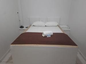 uma cama com duas toalhas num quarto em Londres Royal Hotel - Cama de alvenaria em Londrina