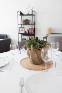 een tafel met wijnglazen en een plant in een mand bij 2ndhomes Charming Central 1BR City Apartment with Great Location in Helsinki