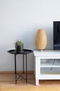duas mesas com uma planta sobre eles ao lado de uma tv em 2ndhomes Charming Central 1BR City Apartment with Great Location em Helsinque