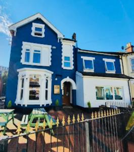 a blue house with a table and chairs in front of it at Circle Guest House Bed Only in Southampton