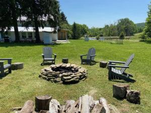HancockにあるFRENCH WOODS FARMHOUSE Catskills Upper Delaware River Hancock NYの火の周りに座る椅子のグループ +72枚の写真